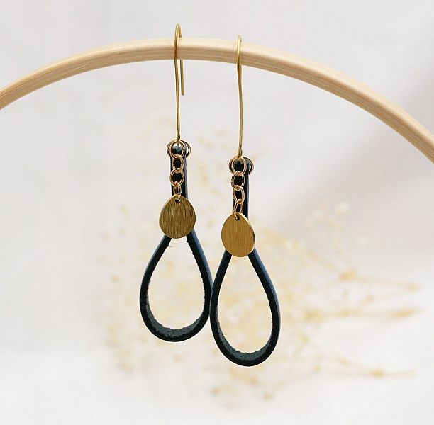 Boucles d'oreilles pendantes en cuir bleu et pampilles dorées.