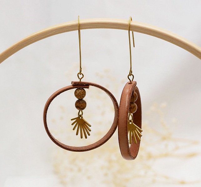 Boucles d'oreilles rondes en cuir naturel avec perles dorées.