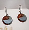 Boucles d'oreilles graphiques en bois avec pendentif feuille cuivrée.