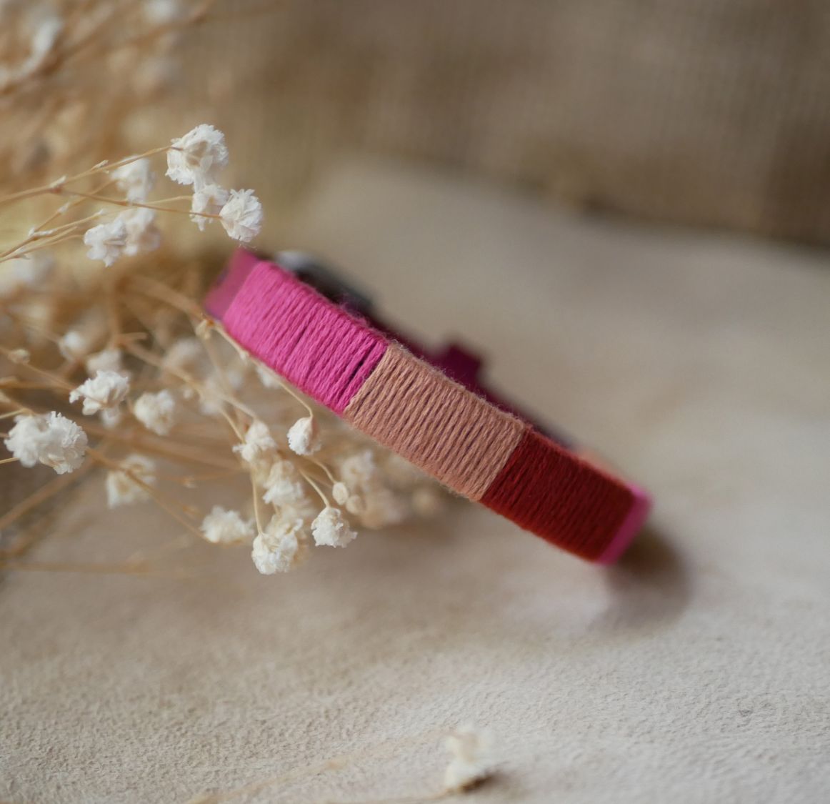 Bracelet en cuir fuchsia style boh&egrave;me tiss&eacute; de fils de coton tons p&ecirc;ches et roses
