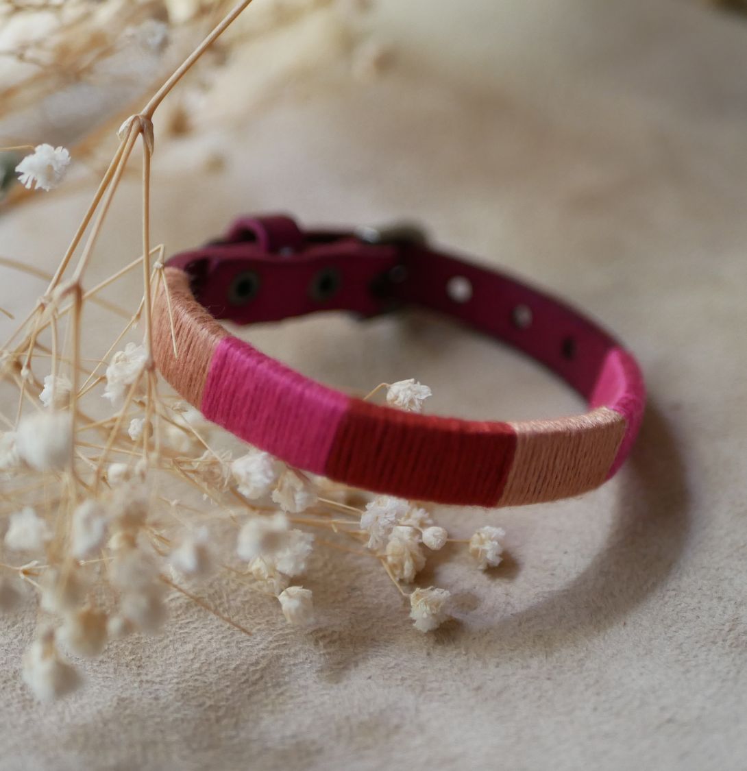 Bracelet en cuir fuchsia style boh&egrave;me tiss&eacute; de fils de coton tons p&ecirc;ches et roses
