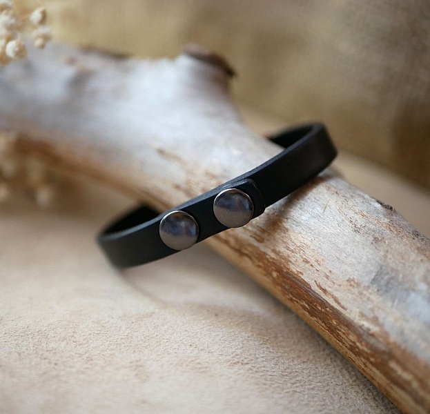 Bracelet homme en cuir noir avec boutons pression métalliques.