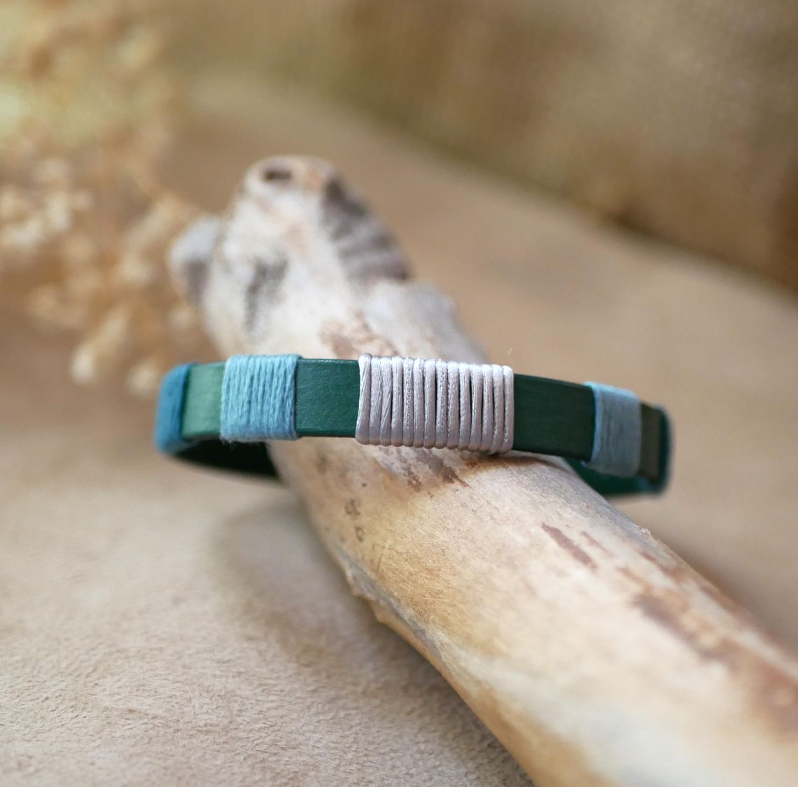 Bracelet en cuir vert tissé de fils bleu et argent.