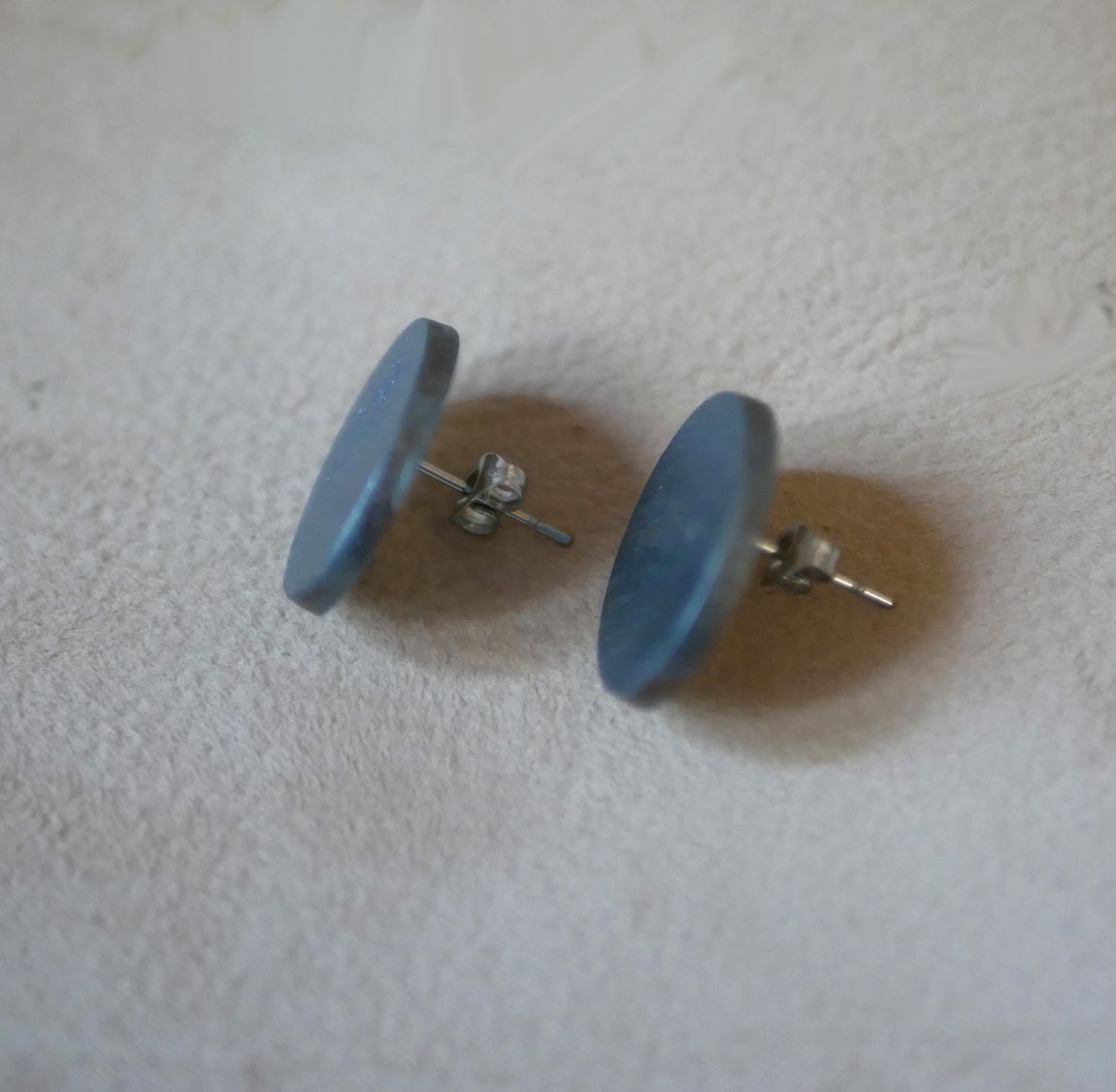 Puces d'oreilles ovales en bois peint gris effet métallisé.
