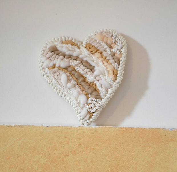 Cœur décoratif mural en tissage de laines blanches et beiges.
