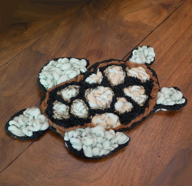 Décoration murale tortue artisanale en tissage de laine colorée.