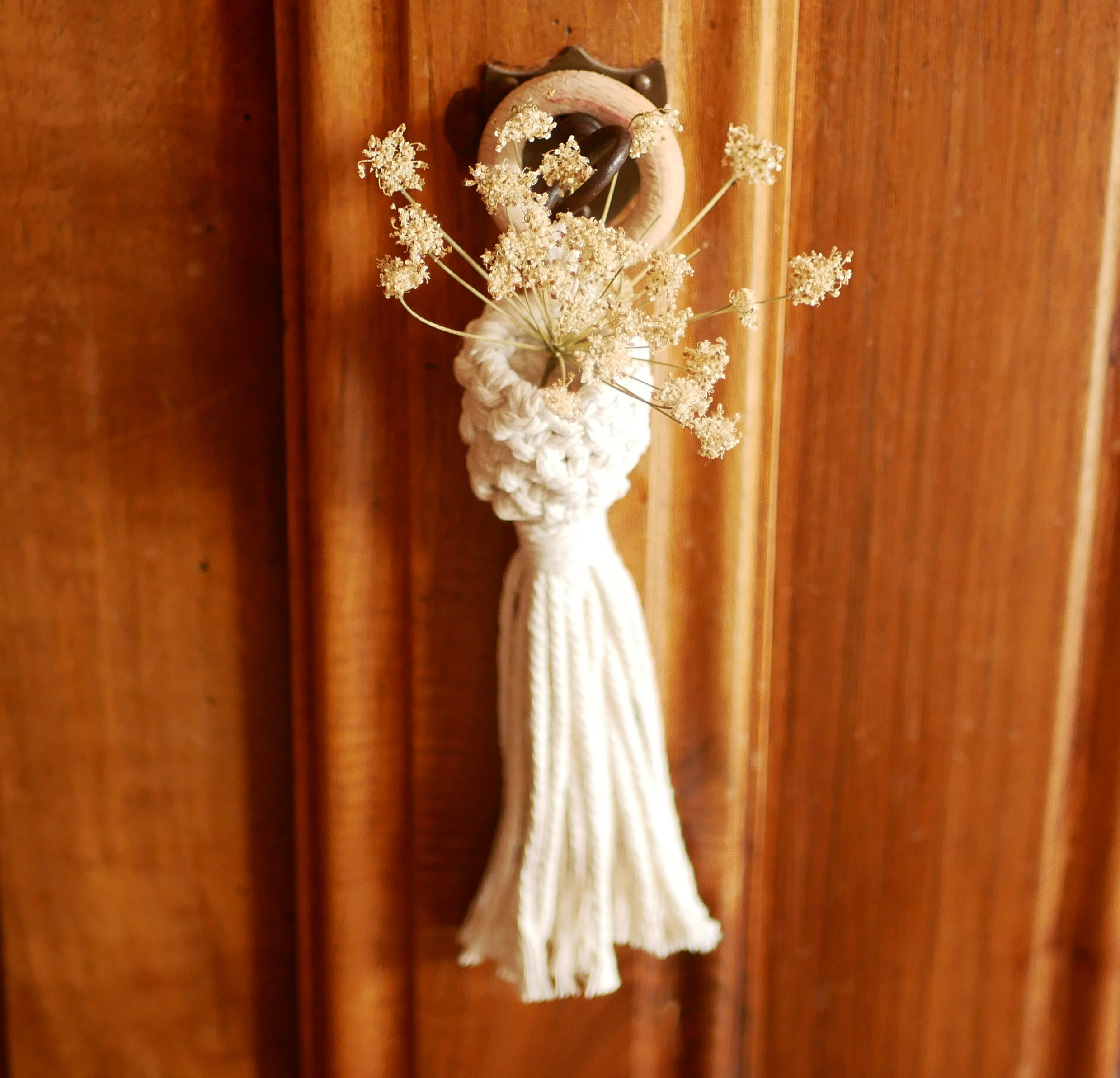 Mini suspension macramé écrue avec fleurs séchées sur porte.