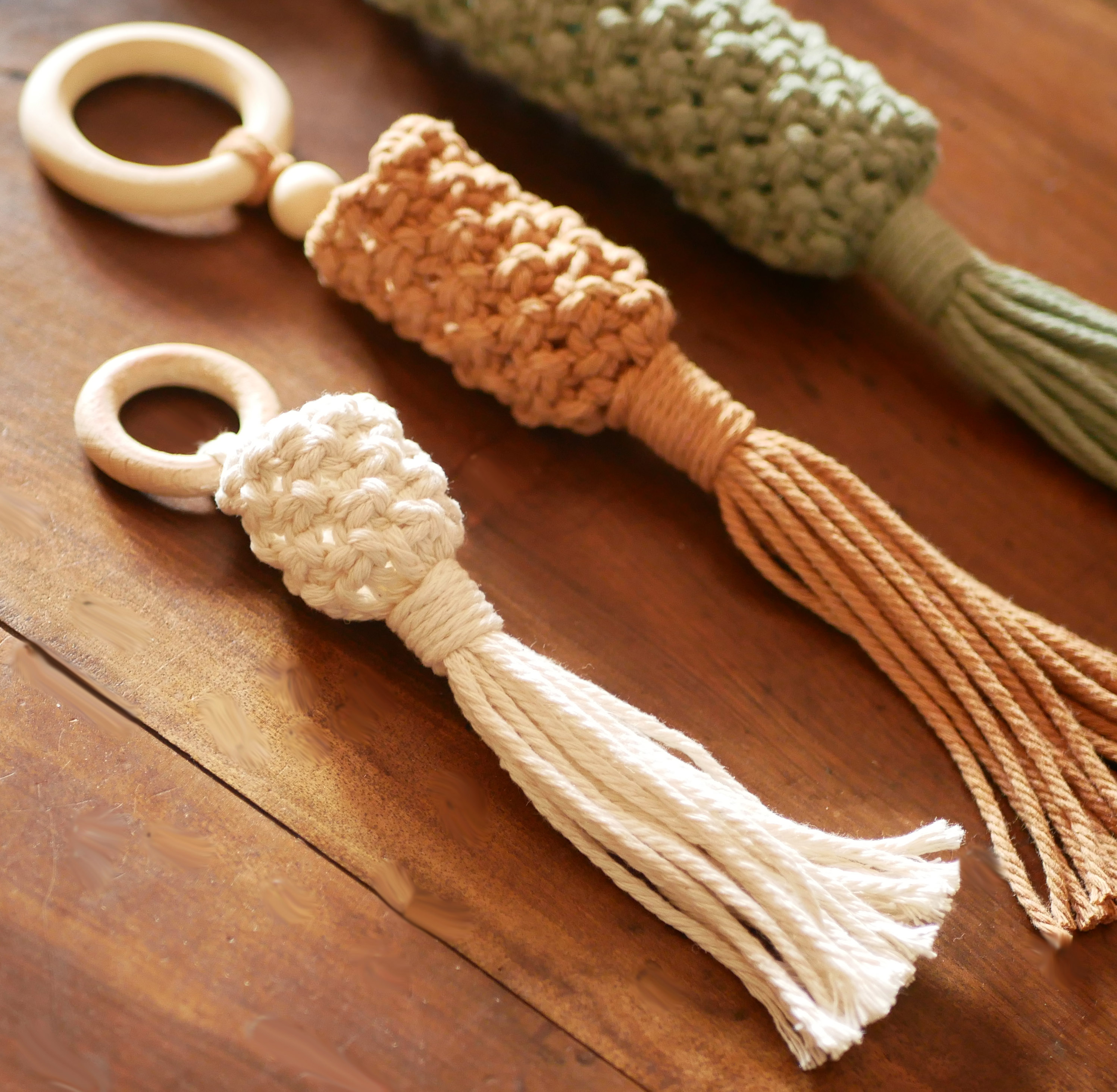 Suspensions artisanales en macramé avec anneaux en bois naturel.