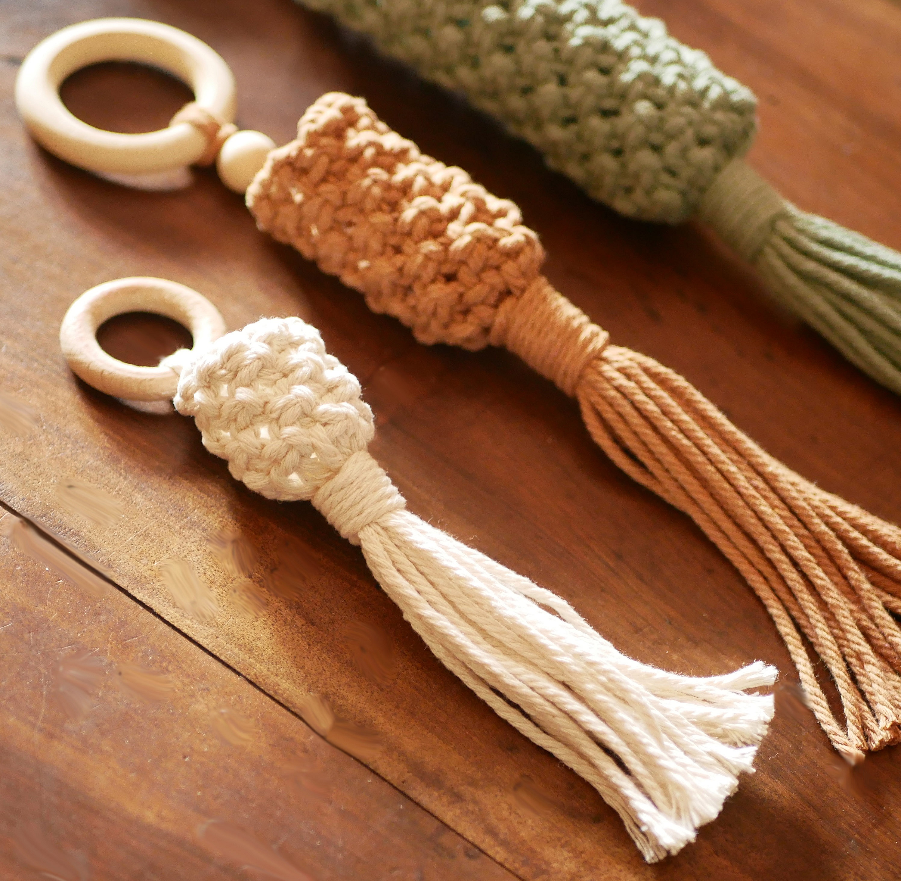 Suspensions artisanales en macramé avec anneaux en bois naturel.