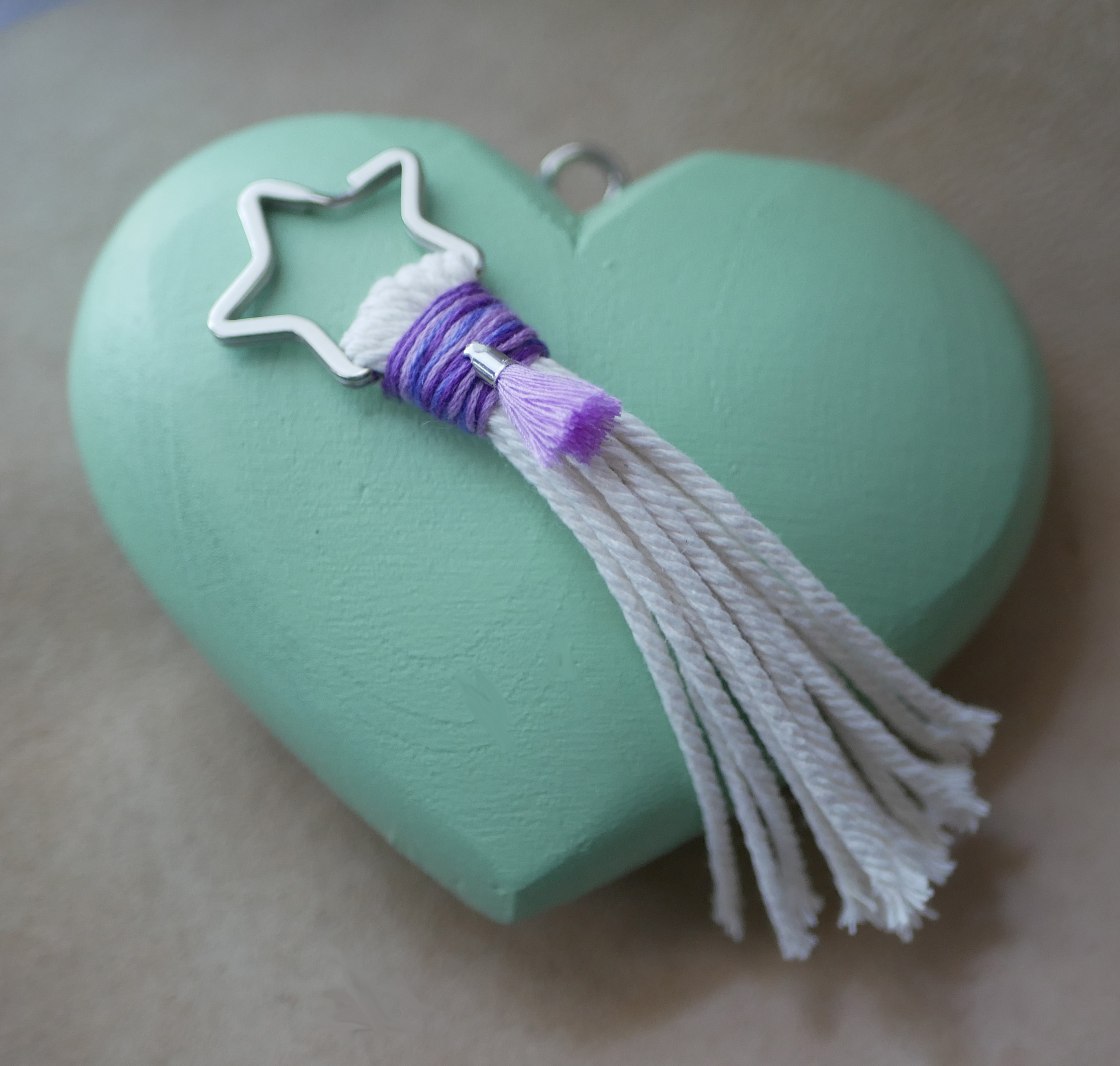 Porte-clé macramé étoile avec pompon violet sur cœur vert.