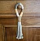 Suspension pompon en macramé pour poignée de porte en bois.