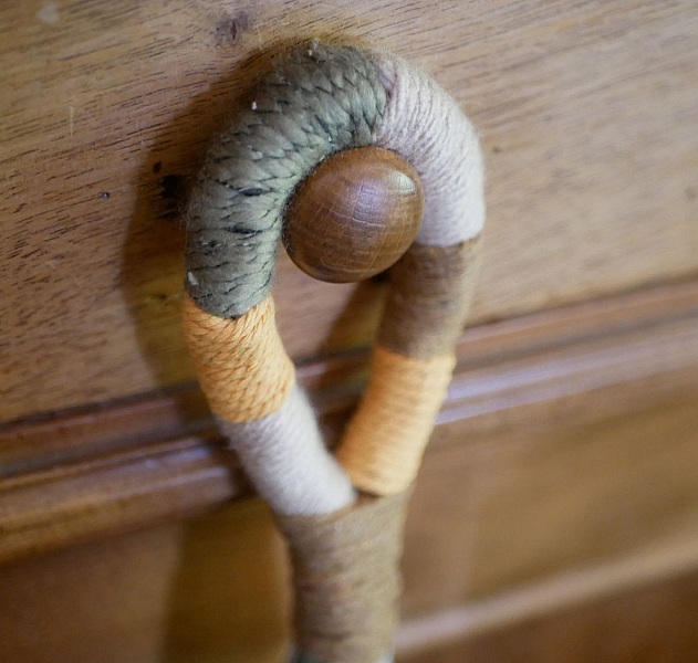 Suspension en macramé coloré pour poignée de porte en bois.