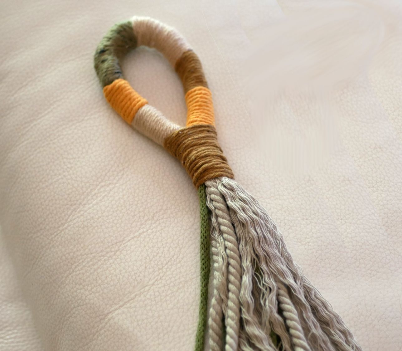 Suspension pompon en macramé coloré pour poignée de porte.