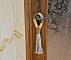 Suspension pompon en macramé décorant une poignée de porte.