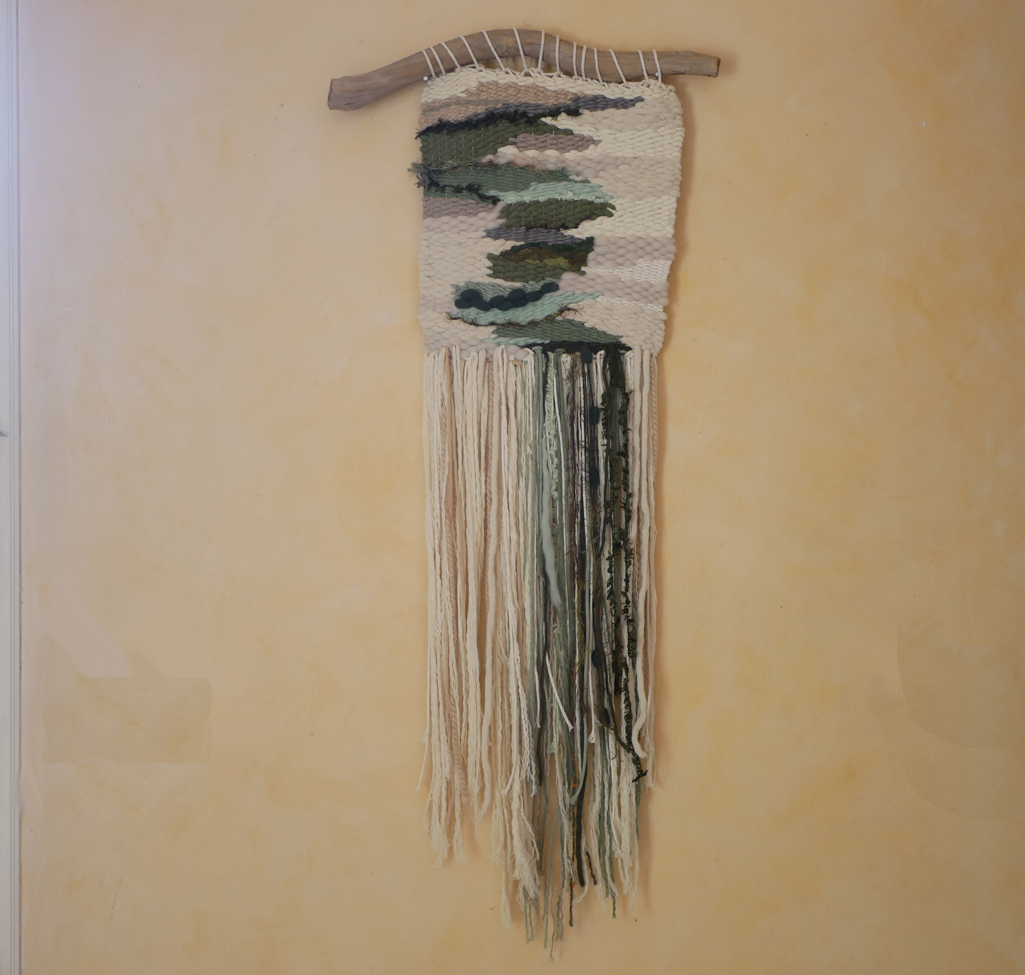 Suspension tissage mural "Les rivi&egrave;res v&eacute;g&eacute;tales" en laines et coton de couleurs vert d'eau et longues franges