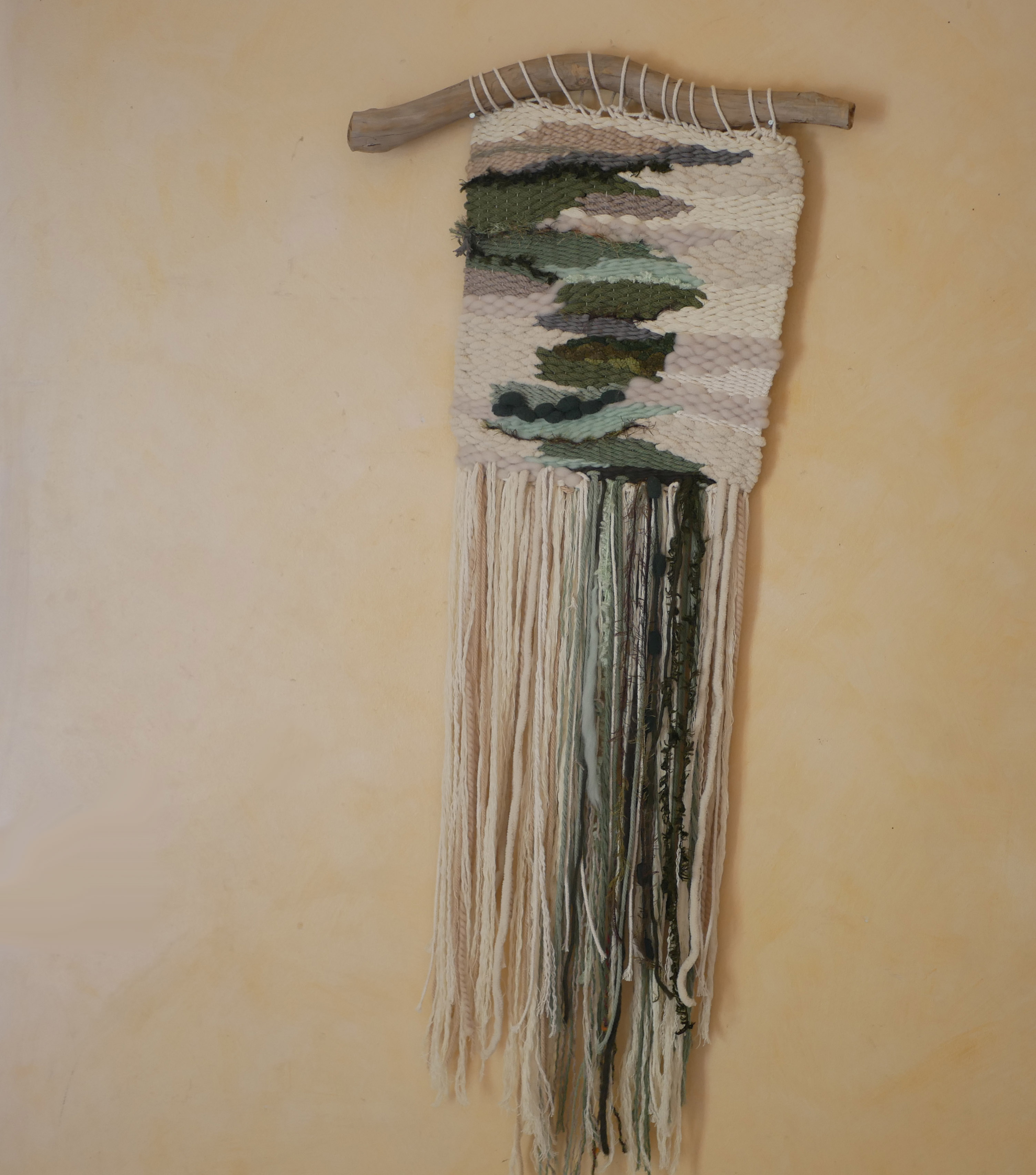 Suspension tissage mural "Les rivi&egrave;res v&eacute;g&eacute;tales" en laines et coton de couleurs vert d'eau et longues franges