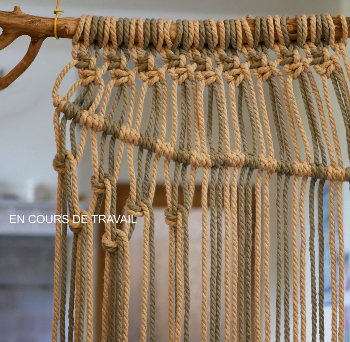 Tenture murale en macramé avec tissage de laines colorées.