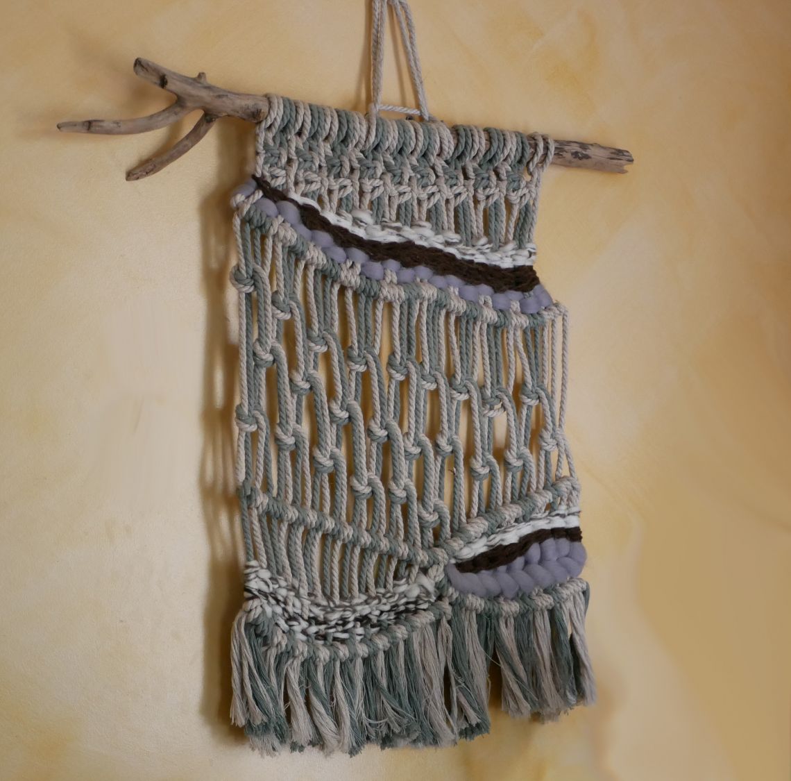 Tenture murale en macramé avec tissage de laines colorées.
