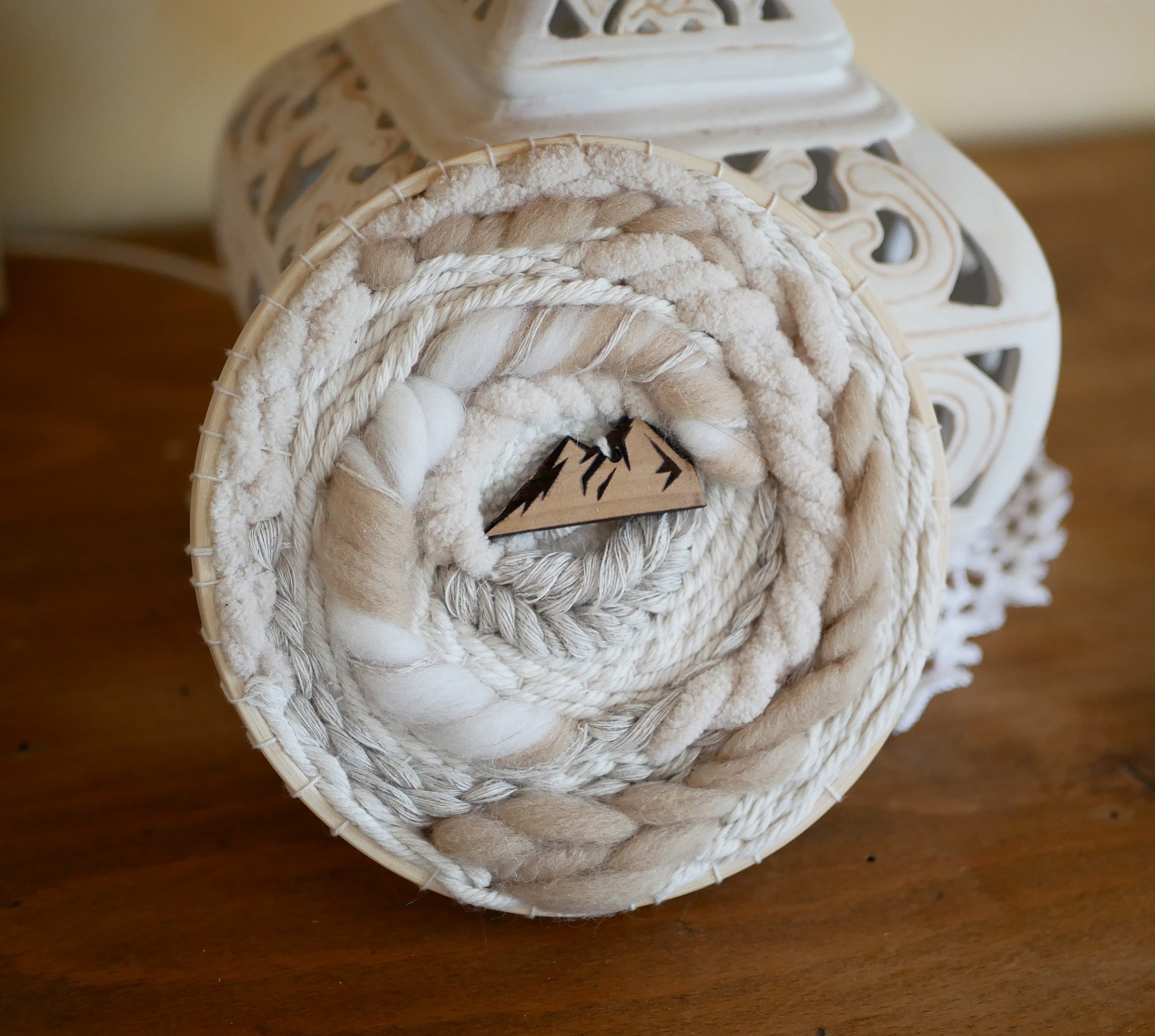 Tissage mural rond en macramé avec motif montagne en laine.