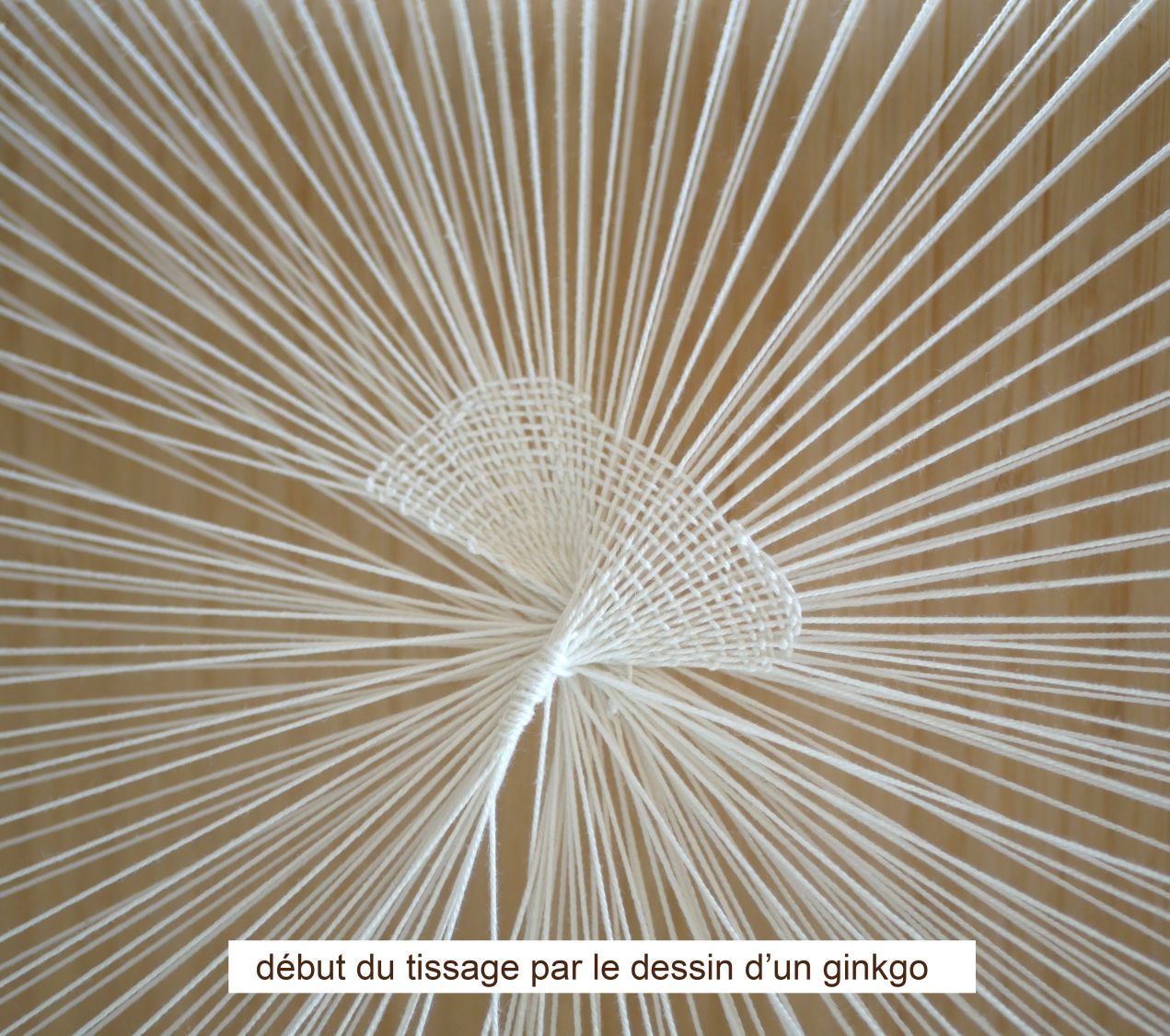 Tissage mural rond en laine représentant une feuille de ginkgo.