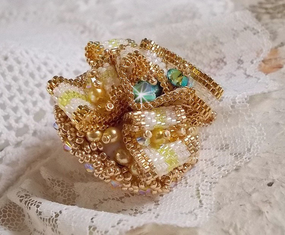Bague Sunflower Gold brod&eacute;e d&rsquo;un ruban que j&rsquo;ai mis en forme avec des rocailles plaqu&eacute;es or 24 carats, perles nacr&eacute;es en cristal, toupies, perle ronde nacr&eacute;e. Le tout est mont&eacute; sur une bague Dor&eacute;e