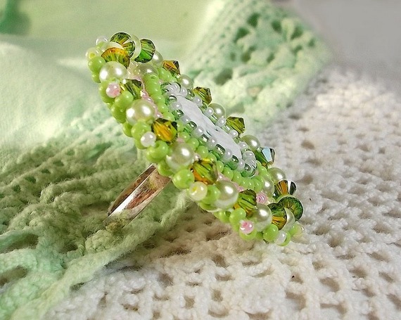 Bague Anisse brod&eacute;e d&rsquo;un cabochon r&eacute;sine repr&eacute;sentant une femme et des roses, orn&eacute;e de rocailles Vert Anis, Rose, Jaune Nacr&eacute; et Ivoire. Elle est finie avec des toupies et perles sur bague r&eacute;glable 