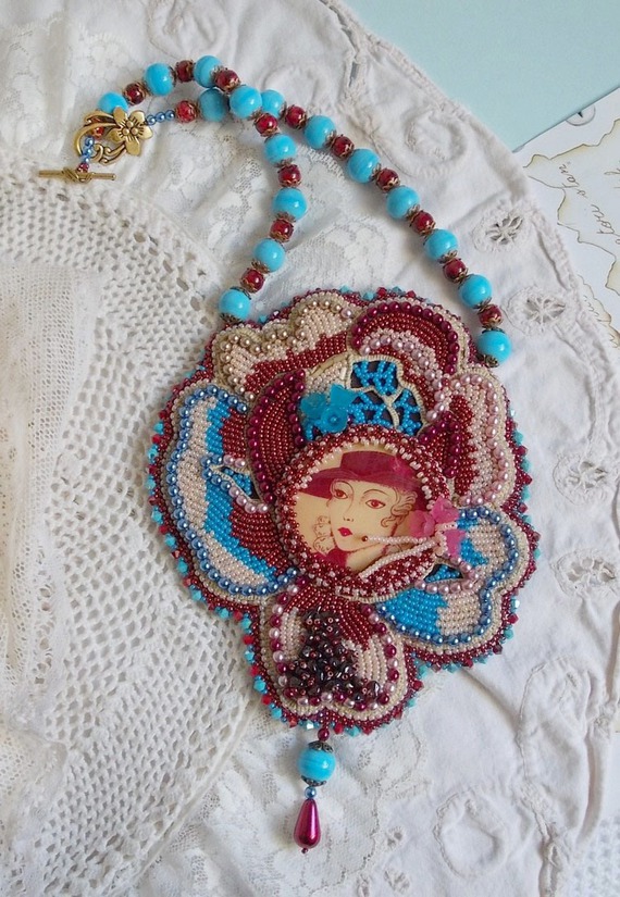 Collier brodé artisanal avec cabochon vintage et perles colorées.