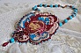 Collier brodé artisanal avec cabochon vintage et perles colorées.