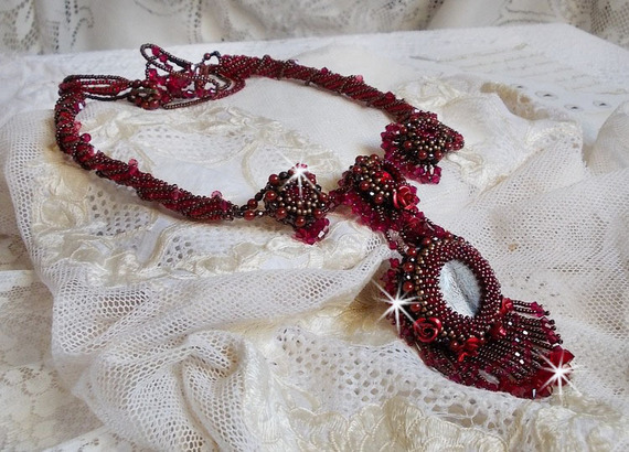 Collier Rubby One brod&eacute;  avec un cabochon en c&eacute;ramique de couleur Gris/Marron &agrave; laquelle s'ajoute des cabochons ronds en Cristal Siam, rocailles Bronze, toupies Light Rose et Rubby avec fermoir en T