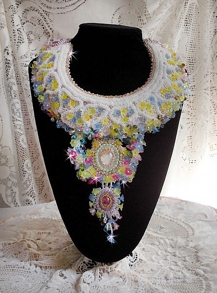 Plastron Envol&eacute;e Fleurie Haute Couture brod&eacute; avec des cabochons Nacre et R&eacute;sine aux couleurs Fuchsia et Ivoire, s&rsquo;ajoute des fleurs lucites, feuilles en verre, chatons et perles en Cristal.