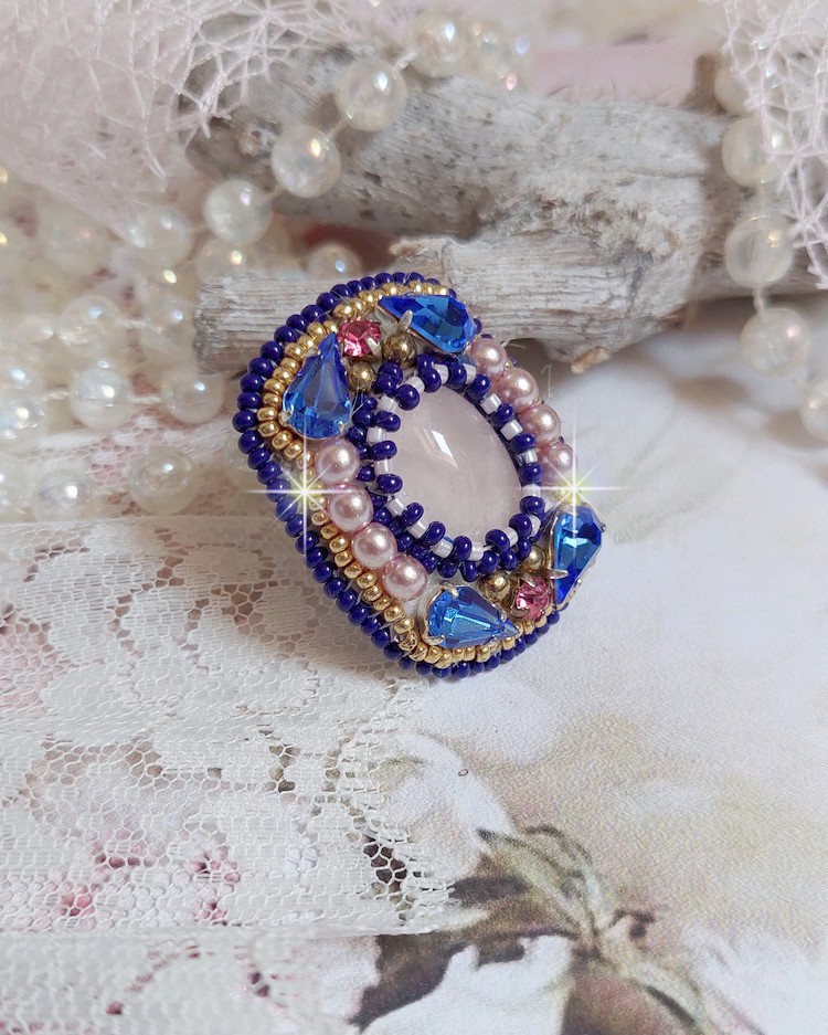 Bague Gabrielle brod&eacute;e avec un cabochon ovale en pierre de gemme : le Quartz Rose &agrave; laquelle s'ajoute des cabochons poires et chatons en Cristal, perles nacr&eacute;es, rocailles sur bague en laiton Bronze