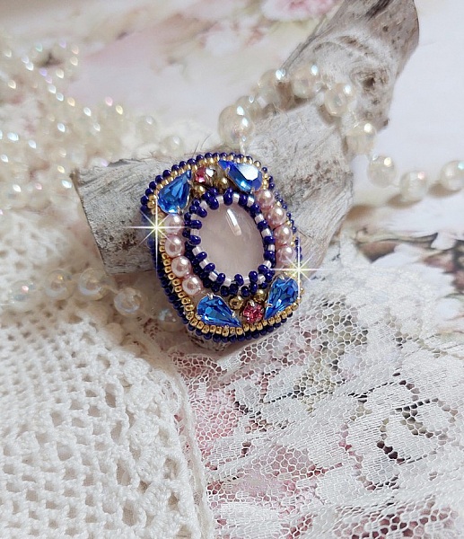 Bague Gabrielle brod&eacute;e avec un cabochon ovale en pierre de gemme : le Quartz Rose &agrave; laquelle s'ajoute des cabochons poires et chatons en Cristal, perles nacr&eacute;es, rocailles sur bague en laiton Bronze