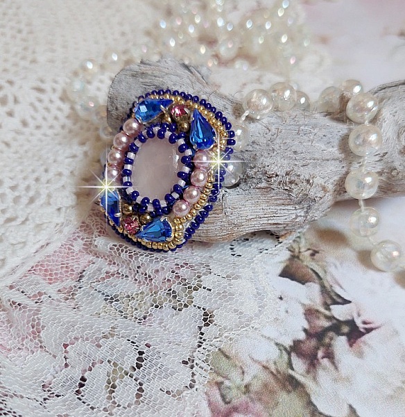 Bague Gabrielle brod&eacute;e avec un cabochon ovale en pierre de gemme : le Quartz Rose &agrave; laquelle s'ajoute des cabochons poires et chatons en Cristal, perles nacr&eacute;es, rocailles sur bague en laiton Bronze