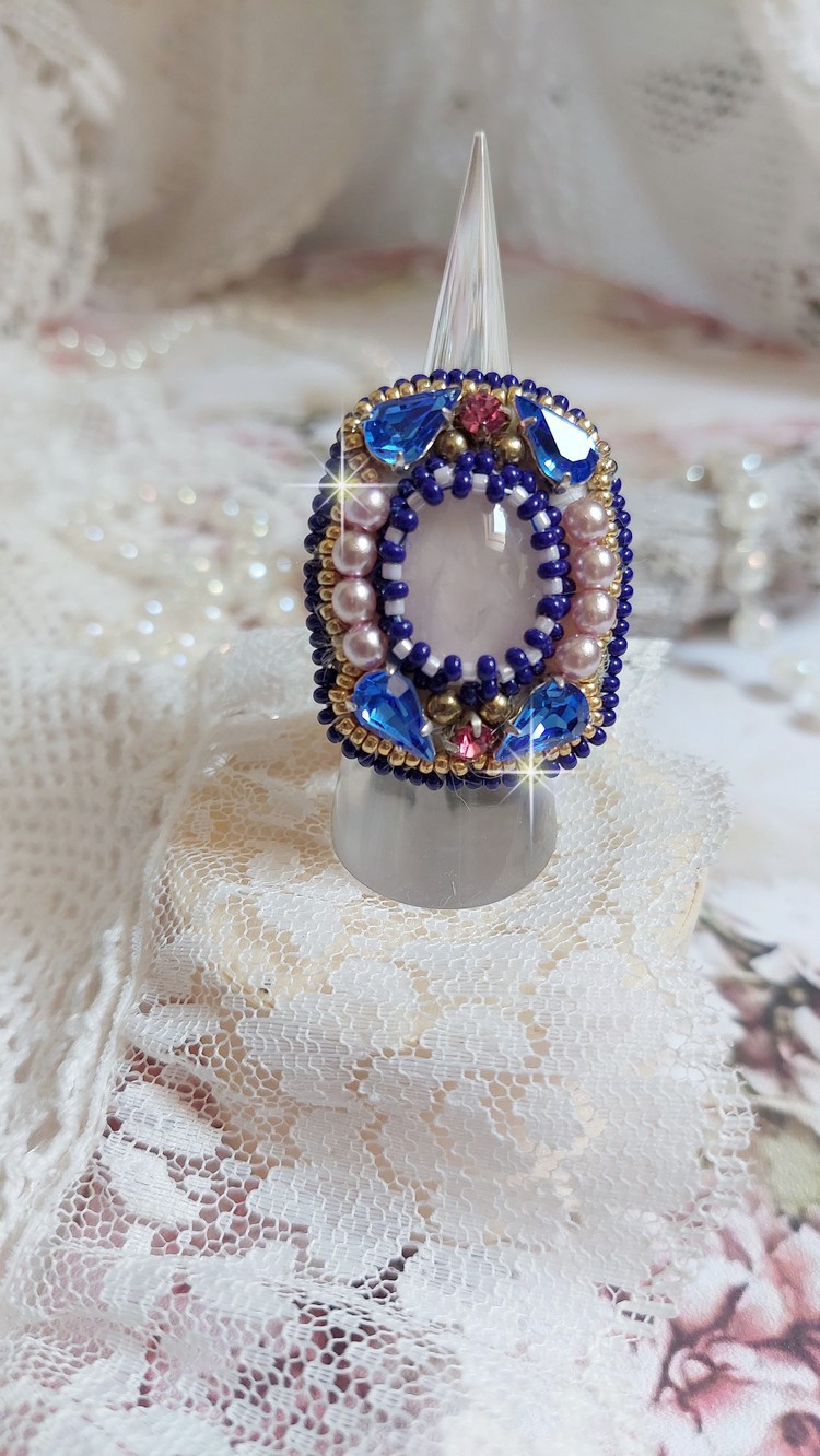 Bague Gabrielle brod&eacute;e avec un cabochon ovale en pierre de gemme : le Quartz Rose &agrave; laquelle s'ajoute des cabochons poires et chatons en Cristal, perles nacr&eacute;es, rocailles sur bague en laiton Bronze