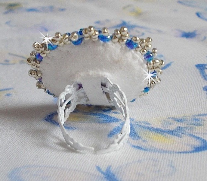 Bague Azur brod&eacute;e avec un cabochon en Cristal de couleur Antique Pink &agrave; laquelle s'ajoute des rocailles et perles rondes nacr&eacute;es. Le tout est mont&eacute; sur une bague filigran&eacute;e Blanche