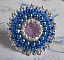 Bague Azur brod&eacute;e avec un cabochon en Cristal de couleur Antique Pink &agrave; laquelle s'ajoute des rocailles et perles rondes nacr&eacute;es. Le tout est mont&eacute; sur une bague filigran&eacute;e Blanche