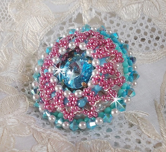 Bague Beauty Alicia Blue brod&eacute;e avec un cabochon en Cristal Bleu, perles nacr&eacute;es Blanches, toupies Turquoises AB2x et rocailles. Le tout est mont&eacute; sur une bague filigran&eacute;e Bleue, un style contemporain