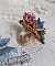 Bague Bel Air mont&eacute;e avec des fleurs lucites peintes &agrave; la main aux couleurs : Bleu, Rose, Rouge, Argent, Blanc avec feuilles ondul&eacute;es Vert Cuivr&eacute; &agrave; laquelle s&rsquo;ajoute perles Dor&eacute;es en Verre
