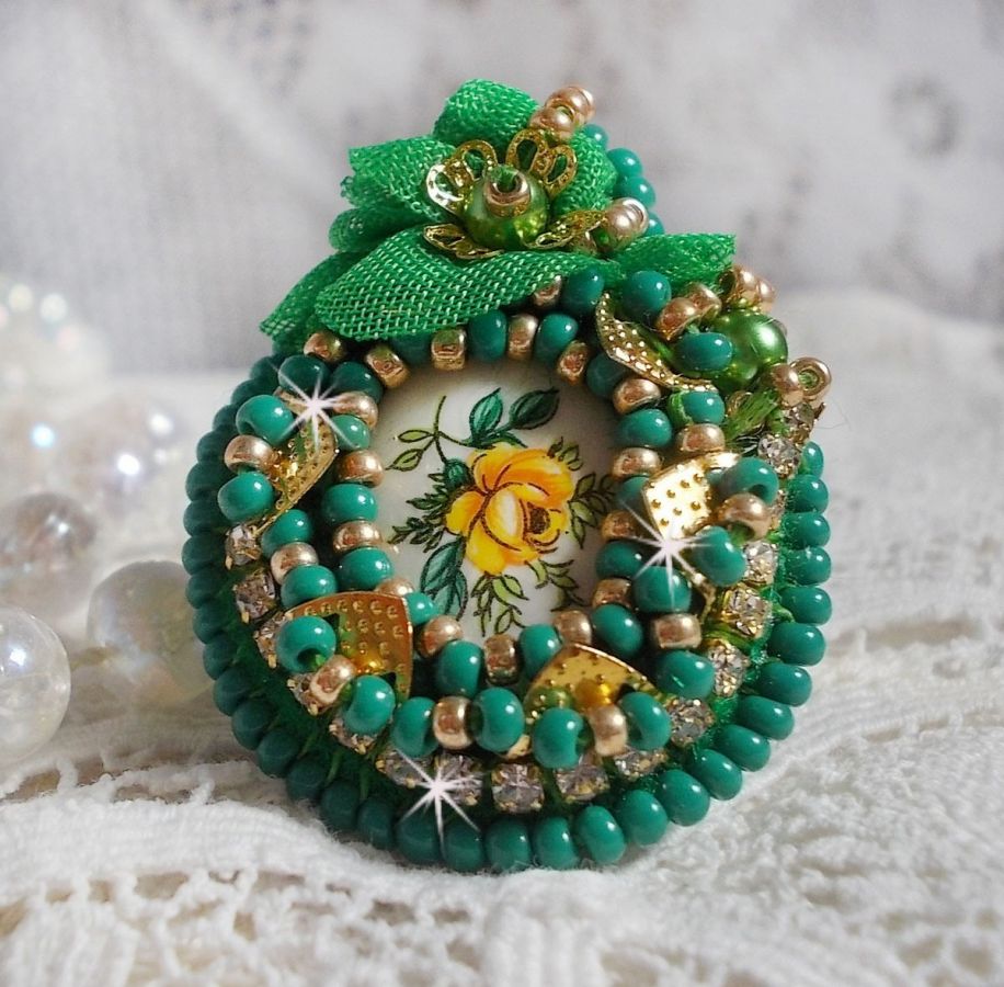 Bague Belle Emeraude brod&eacute;e avec un cabochon ovale en c&eacute;ramique repr&eacute;sentant une rose Jaune sur fond Blanc, un tissu l&eacute;ger de couleur Vert, des perles rondes nacr&eacute;es et des rocailles Dor&eacute;es