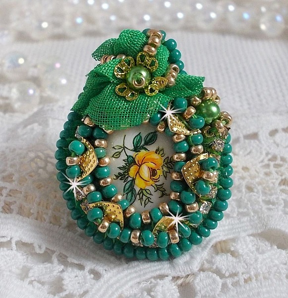 Bague Belle Emeraude brod&eacute;e avec un cabochon ovale en c&eacute;ramique repr&eacute;sentant une rose Jaune sur fond Blanc, un tissu l&eacute;ger de couleur Vert, des perles rondes nacr&eacute;es et des rocailles Dor&eacute;es