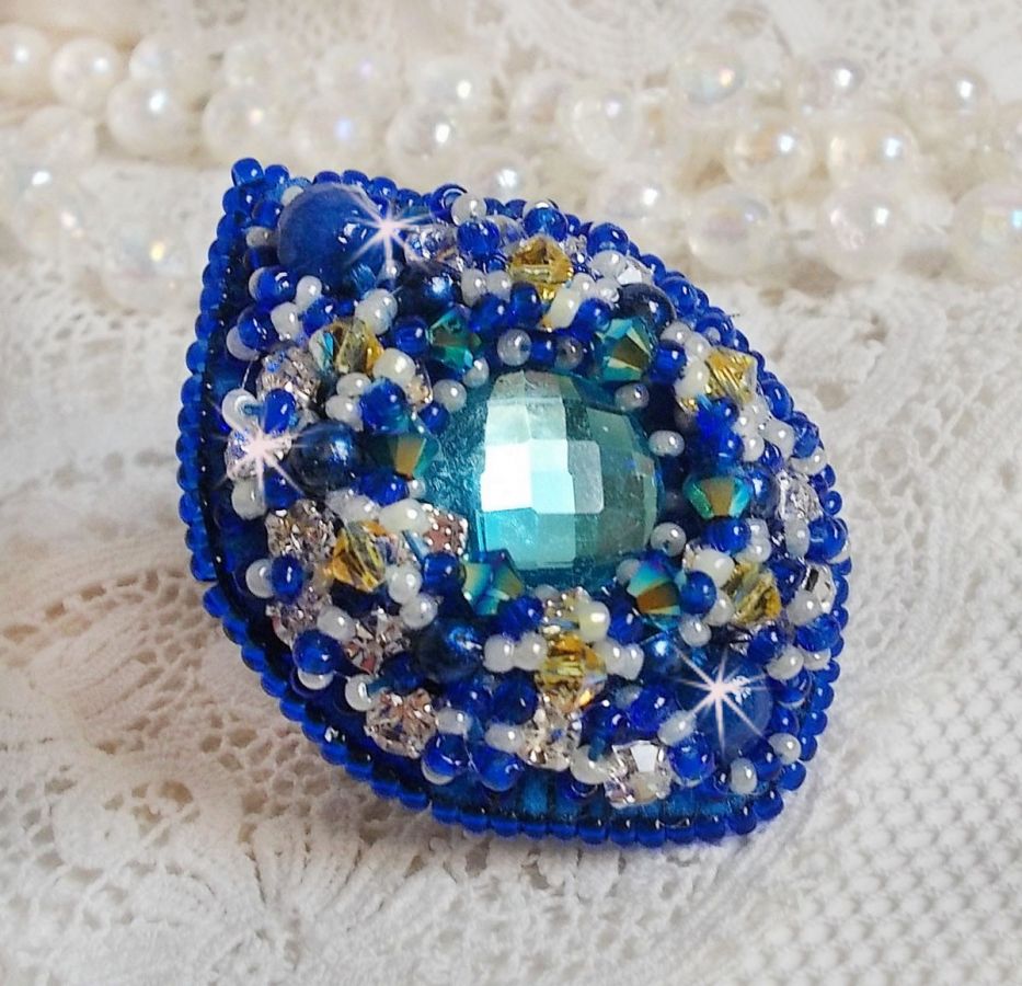 Bague Blue Palace brod&eacute;e avec un cabochon rond facett&eacute; Turquoise, des perles rondes nacr&eacute;es, estampe filigran&eacute;e, chatons, toupies en Cristal, rocailles et perles sur une bague filigran&eacute;e Argent&eacute;e