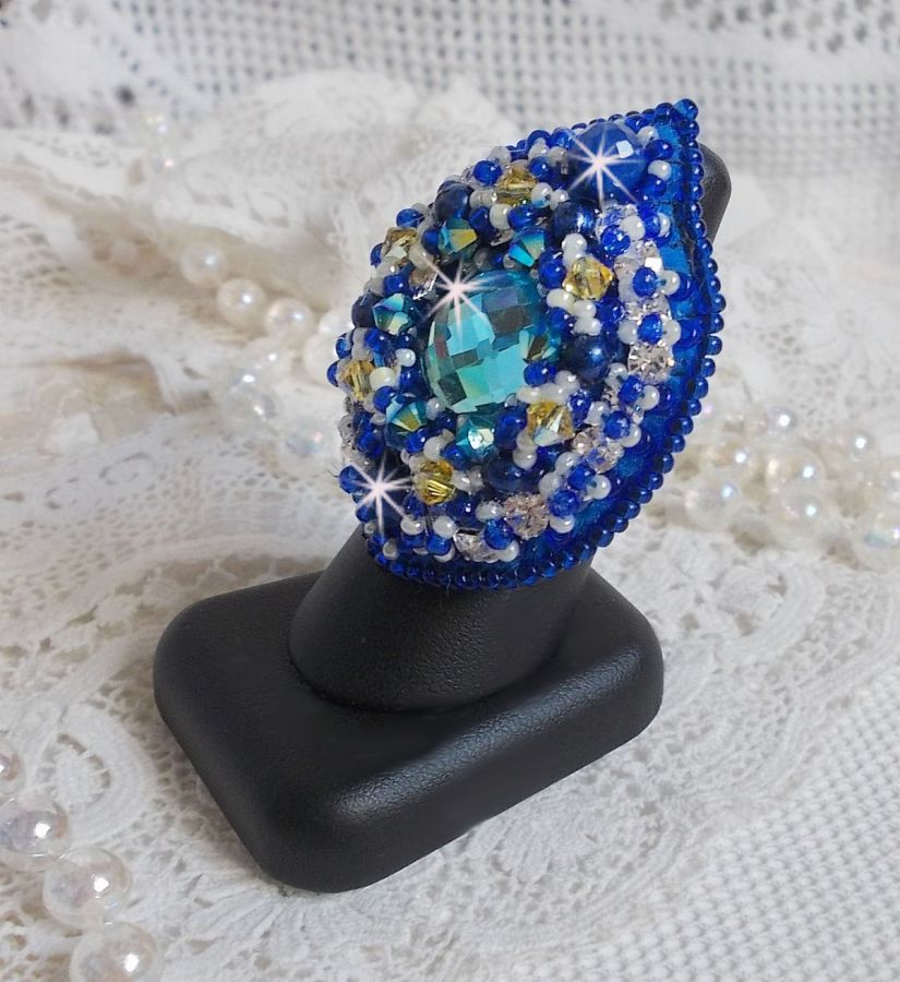 Bague Blue Palace brod&eacute;e avec un cabochon rond facett&eacute; Turquoise, des perles rondes nacr&eacute;es, estampe filigran&eacute;e, chatons, toupies en Cristal, rocailles et perles sur une bague filigran&eacute;e Argent&eacute;e
