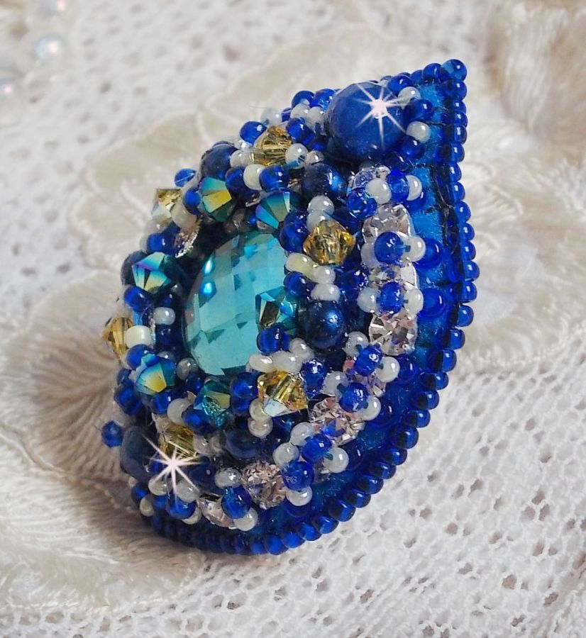 Bague Blue Palace brod&eacute;e avec un cabochon rond facett&eacute; Turquoise, des perles rondes nacr&eacute;es, estampe filigran&eacute;e, chatons, toupies en Cristal, rocailles et perles sur une bague filigran&eacute;e Argent&eacute;e