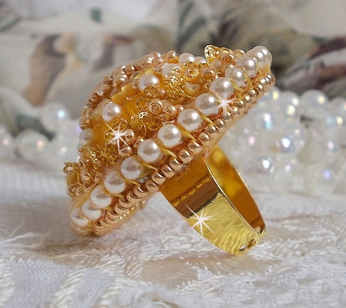 Bague artisanale brodée en perles dorées et nacrées.