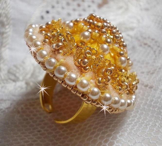 Bague artisanale brodée en perles nacrées et rocailles dorées.