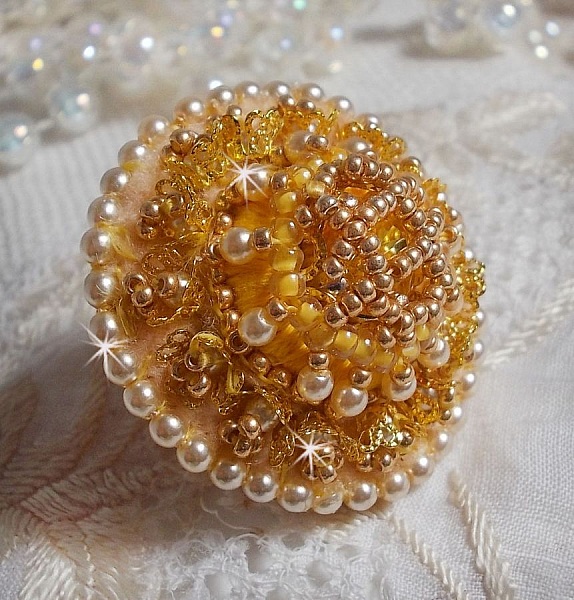 Bague artisanale brodée en perles dorées et nacrées ivoire.