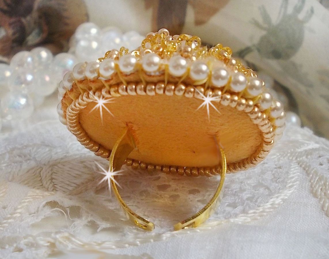 Bague artisanale brodée jaune avec perles nacrées et dorées.