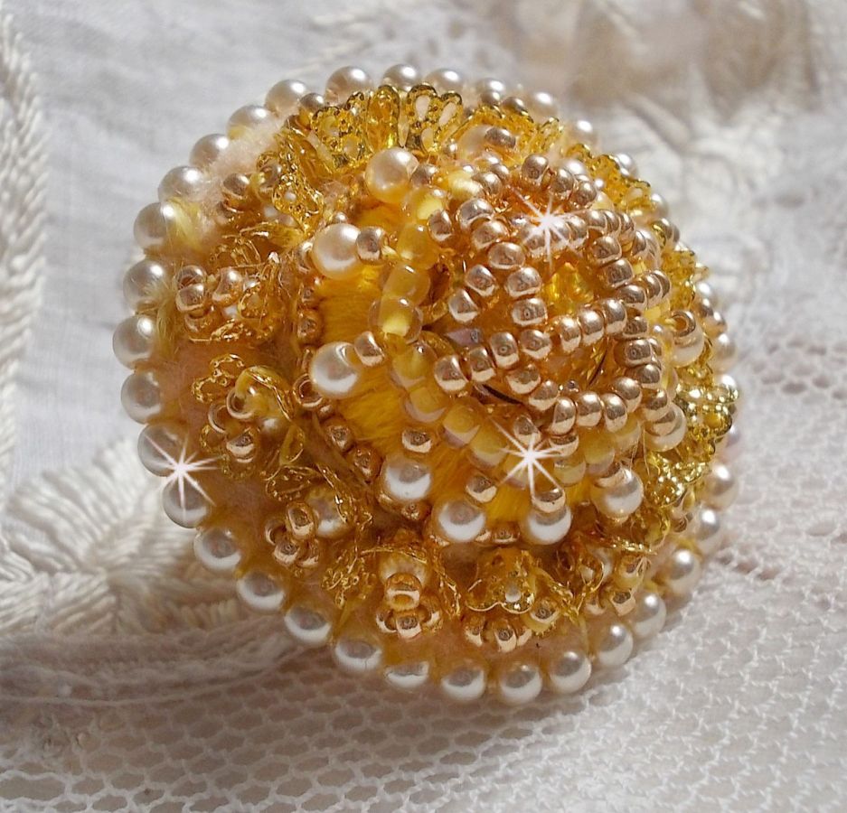 Bague artisanale brodée jaune avec perles nacrées et rocailles.
