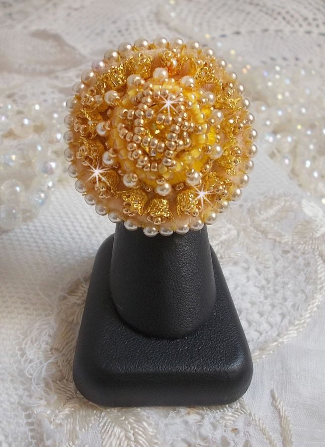 Bague artisanale brodée en perles dorées et nacrées.