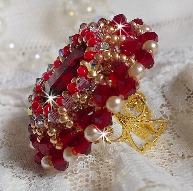 Bague Rubis brod&eacute;e avec un cabochon rectangulaire Ruby, orn&eacute;e de chatons mont&eacute;s en Cristal avec des perles rondes nacr&eacute;es en verre Ivoire, rocailles Dor&eacute;es, des toupies Cristal AB et Burgundy.